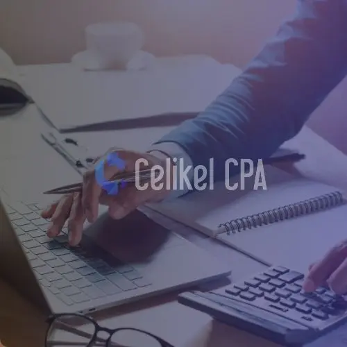 A professional working on a laptop and using a calculator on a desk, symbolizing accounting and financial processes. Image relates to the essential guide for obtaining a Turkish Tax ID